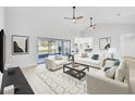 Bright and airy living room with white sofas, large windows, and a view of the pool at 2024 N Pebble Beach Blvd, Sun City Center, FL 33573