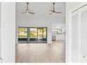 Spacious living area with light hardwood floors and view of the kitchen and backyard at 2024 N Pebble Beach Blvd, Sun City Center, FL 33573