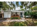 White bungalow with a covered porch and lush landscaping, offering curb appeal at 2883 16Th Ave N, St Petersburg, FL 33713