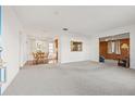 Bright and spacious living room with wood-paneled accent wall and carpeted floors at 3110 W Powhatan Ave, Tampa, FL 33614