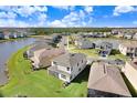 Aerial view of a lakefront community with numerous houses at 3278 Woodland Brook Way, Wesley Chapel, FL 33543