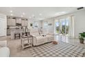 Living area with white reclining sofa and view to backyard at 35980 Morse Willow Ct, Zephyrhills, FL 33541