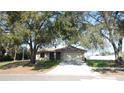 Charming house nestled under large oak trees with a paved driveway at 36150 Pine Bluff Loop, Dade City, FL 33525
