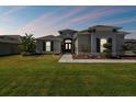 House exterior at dusk, featuring a walkway and landscaping at 5226 Lake Venice Dr, Wimauma, FL 33598