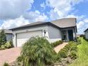 Single-story home with white garage door and landscaped front yard at 5519 Blue Crush Bnd, Land O Lakes, FL 34638