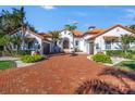White stucco home with terracotta tile roof, brick driveway, and palm trees at 751 34Th Ne Ave, St Petersburg, FL 33704