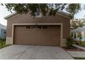 Tan house with attached garage and driveway, front yard view at 10438 Blackmore Dr, Tampa, FL 33647