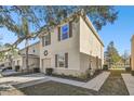 Tan two-story townhome with brown accents, showcasing side yard and driveway at 12816 Buffalo Run Dr, Gibsonton, FL 33534