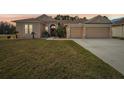 One story house with peach walls, two car garage, and landscaped yard at 13317 Blythewood Dr, Spring Hill, FL 34609