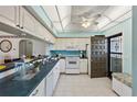 Well-equipped kitchen featuring white cabinetry and a breakfast bar at 1401 Cordova Grn, Seminole, FL 33777