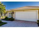 White garage door with herringbone driveway at 15731 Crystal Waters Dr, Wimauma, FL 33598