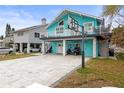 Two-story teal house with a large driveway and a basketball hoop at 17706 1St E St, Redington Shores, FL 33708