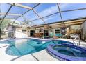 Large kidney-shaped pool with a spa and a covered patio area at 2109 Elmwood Ct, Plant City, FL 33563