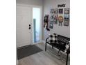 Bright entryway with bench, photo display, and grey floors at 2912 Star Apple Ct, Palm Harbor, FL 34684