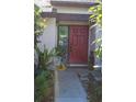 Welcoming front entrance with red door and landscaping at 2912 Star Apple Ct, Palm Harbor, FL 34684