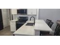 Modern kitchen with white cabinets, quartz countertops, and a breakfast bar at 3611 19Th N St, St Petersburg, FL 33713