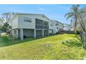 House backyard with a green lawn, wooden fence, and palm trees at 7029 Oakwood Dr, New Port Richey, FL 34652