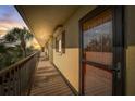 Residential hallway with access to condo unit, offering a glimpse of sunset at 8711 Blind Pass Rd # 307A, St Pete Beach, FL 33706