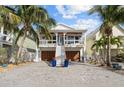 Two-story home with white exterior, inviting front porch, and a meticulously landscaped yard at 12112 Lagoon Ln, Treasure Island, FL 33706