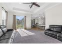 Spacious living room with two black leather sofas and large windows at 13254 Kitty Rd, Weeki Wachee, FL 34614