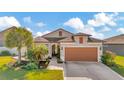 Single-Gathering home with a two-car garage and palm trees in the front yard at 16340 Treasure Point Dr, Wimauma, FL 33598