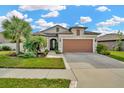 Single-Gathering house with a two-car garage and a well-manicured lawn at 16340 Treasure Point Dr, Wimauma, FL 33598