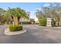 Gated community entrance with lush landscaping and palm trees at 3117 Bayshore Oaks Dr, Tampa, FL 33611