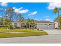 Single story home with a two-car garage and lush landscaping at 3702 Gaviota Dr, Ruskin, FL 33573