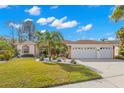 Single-story house with a two car garage and palm trees at 3702 Gaviota Dr, Ruskin, FL 33573