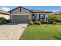 Front view of a single-story house with a paved driveway and palm trees at 5211 Marina Basin Ct, Bradenton, FL 34211