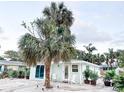 Charming light teal home with a spacious front yard and lush landscaping at 690 Fox St, Longboat Key, FL 34228
