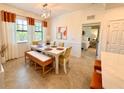 Bright dining room with a white table, woven bench, and yellow chairs at 10059 Crooked Creek Dr # 102, Venice, FL 34293