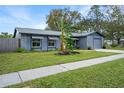 Ranch-style home with gray exterior, striped awnings, and a banana tree at 1125 Westwood Dr, Lutz, FL 33549