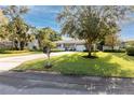 Charming single story home with a lush green lawn and driveway at 121 Live Oak Ln, Largo, FL 33770