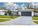 Updated mid-century modern home with a two-car garage and well-manicured lawn at 1448 S Hercules Ave, Clearwater, FL 33764