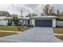 Updated single story home with a gray garage door and well-manicured lawn at 1448 S Hercules Ave, Clearwater, FL 33764