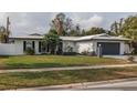 Newly renovated single story home with a gray garage door and neat landscaping at 1448 S Hercules Ave, Clearwater, FL 33764