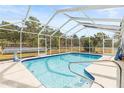 Inviting screened-in pool with solar panels and a surrounding yard at 14912 Brookridge Blvd, Brooksville, FL 34613