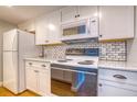 White kitchen with updated appliances and subway tile backsplash at 175 Medallion Blvd # F, Madeira Beach, FL 33708