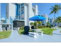 Ground level patio with picnic tables and grill at 175 Medallion Blvd # F, Madeira Beach, FL 33708