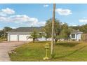 House exterior showcasing a two-car garage and a well-manicured lawn at 18520 Oak Way Dr, Hudson, FL 34667