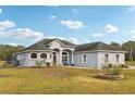 A one-story light blue house with a large front yard and mature trees at 18520 Oak Way Dr, Hudson, FL 34667