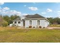 A light blue house with a two-car garage and lush green lawn at 18520 Oak Way Dr, Hudson, FL 34667