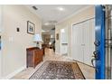 Elegant foyer featuring tile flooring, decorative rug, and a glimpse of the open staircase and living spaces at 18732 Wimbledon Cir, Lutz, FL 33558