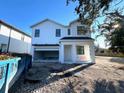 Two-story white house under construction, two-car garage, and partially landscaped yard at 3424 Ohio Ave, Tampa, FL 33611