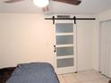 Simple bedroom with a barn door, double bed, and ceiling fan at 4214 Trucious Pl, New Port Richey, FL 34652