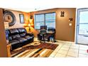 Cozy living room featuring a leather sofa, a home office setup and tile flooring at 4214 Trucious Pl, New Port Richey, FL 34652
