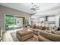 Spacious living room with large sectional sofa, tile floors, and sliding doors leading to pool at 6429 Seasound Dr, Apollo Beach, FL 33572