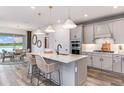 Modern kitchen with gray cabinets, quartz countertops, and stainless steel appliances at 6823 Depue Dr, Wesley Chapel, FL 33545