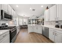 Spacious kitchen featuring white cabinets, stainless steel appliances, and hardwood floors at 11911 Mandevilla Ct, Tampa, FL 33626